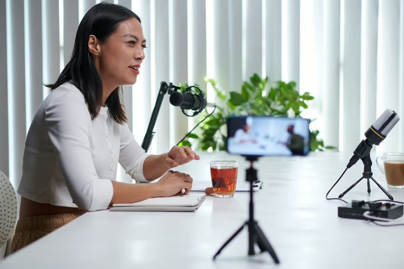 Female executive recording a business podcast to share leadership insights and strengthen her personal brand through strategic communications.